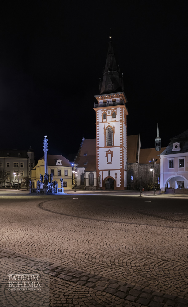 The column with the sculptural group of the Holy Trinity, the town tower, the church of the Assumption of the Virgin Mary and the former town hall. Chomutov.