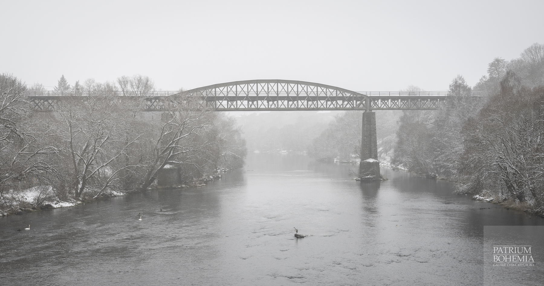 Lehce zasněžený železniční most na 124 kilometru řeky Ohře.