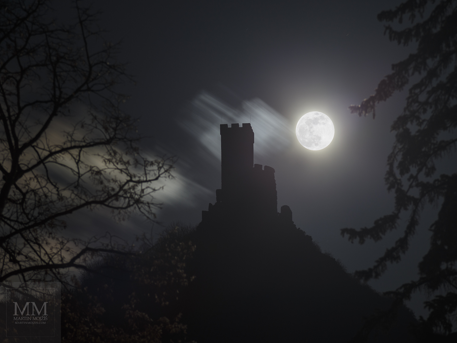 Hrad Klapý (Hazmburk) v noci, velký Měsíc v úplňku.